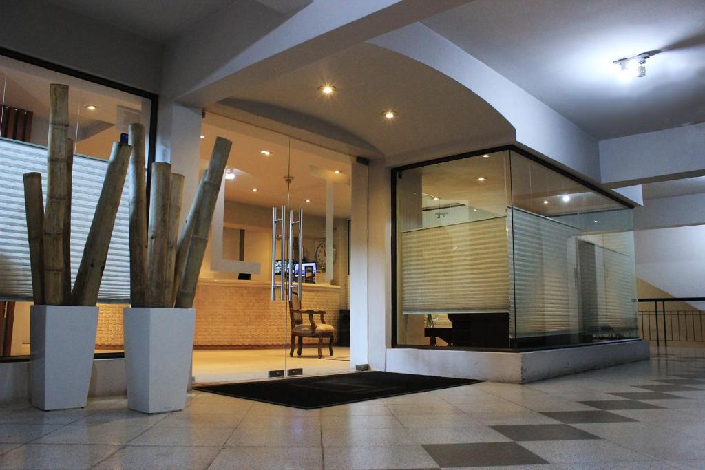 un vestíbulo con una mesa y una silla en un edificio en Hotel Las Terrazas Business en Chillán