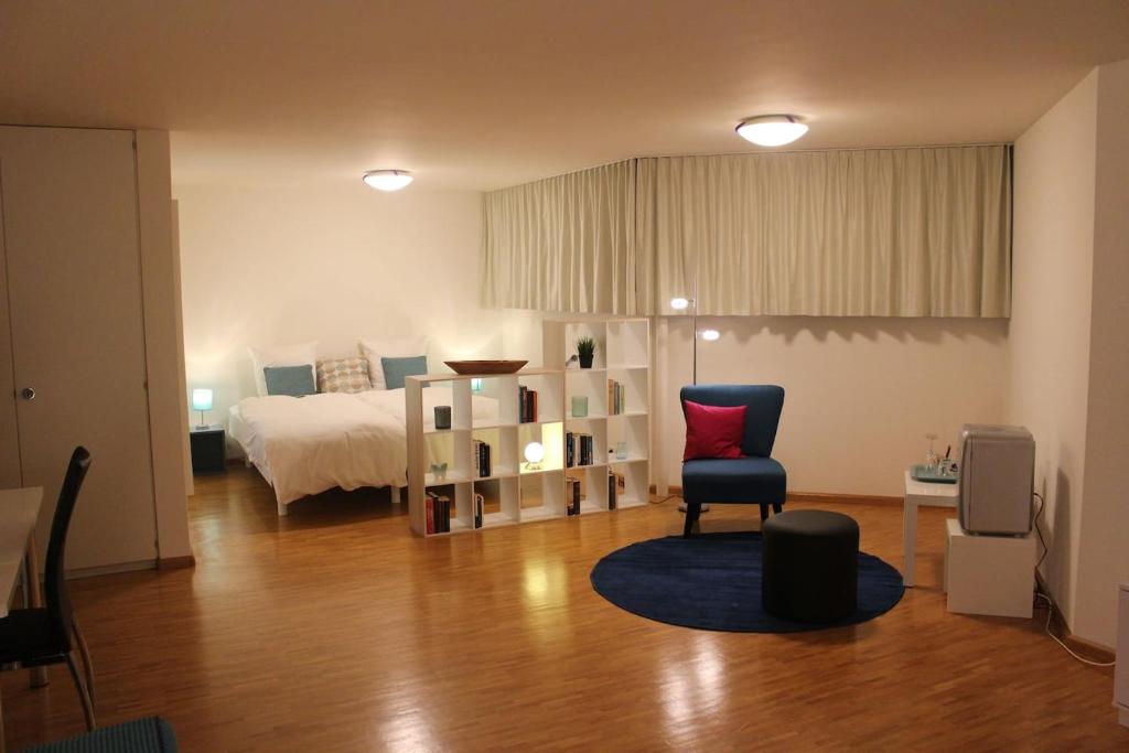 ein Schlafzimmer mit einem Bett und einem Stuhl in einem Zimmer in der Unterkunft A Casa Fina- a modern room close to Basel in Therwil