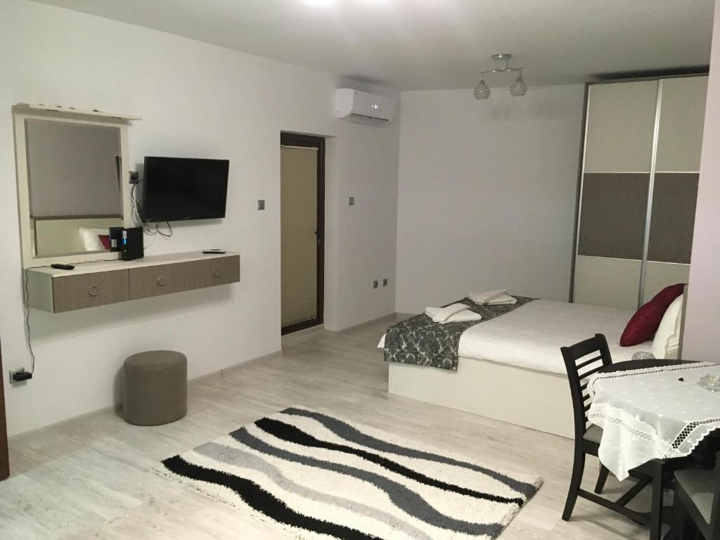 a bedroom with a bed and a television on a wall at Apartment Park Sveti Vrach in Sandanski