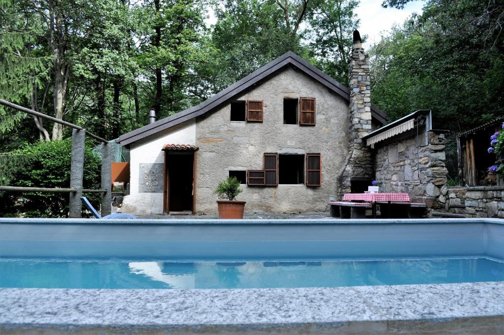 a house with a swimming pool in front of a house at Rustico Gola di Lago in Lelgio