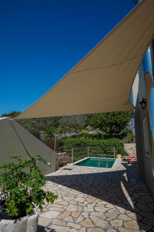 duży parasol na basenie w obiekcie Rosie’s herb house w mieście Karyá