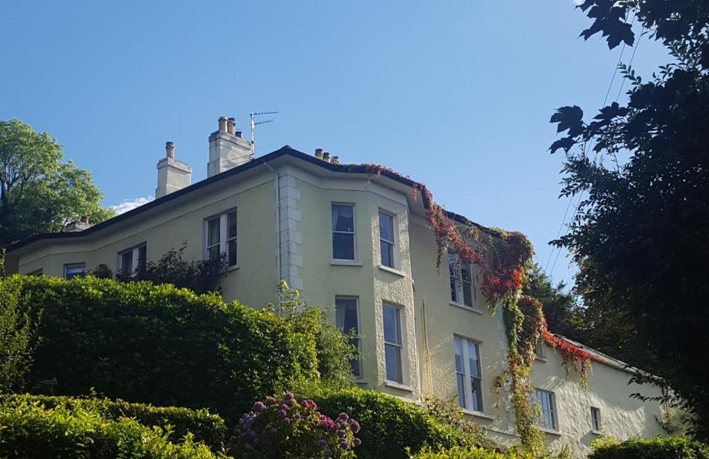 ein weißes Haus mit Pflanzen auf dem Dach in der Unterkunft Riverbank Apartment in Derry Londonderry
