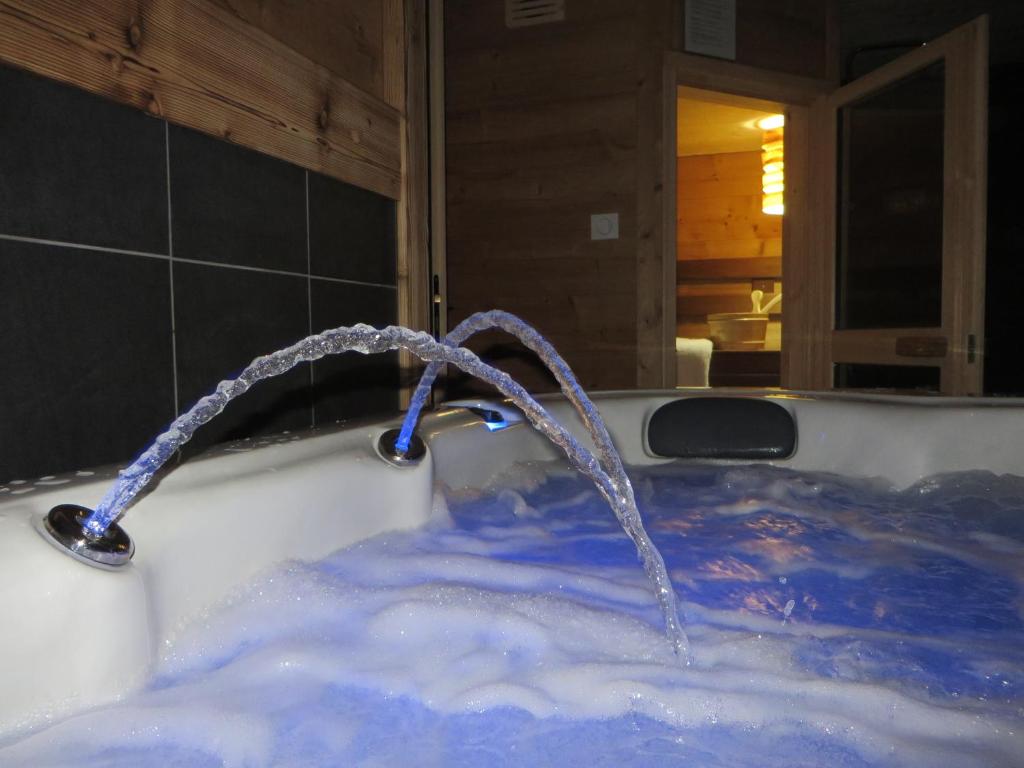 een bad met water dat eruit komt bij LE QUARTZ DES HAUTES-VOSGES in Xonrupt-Longemer