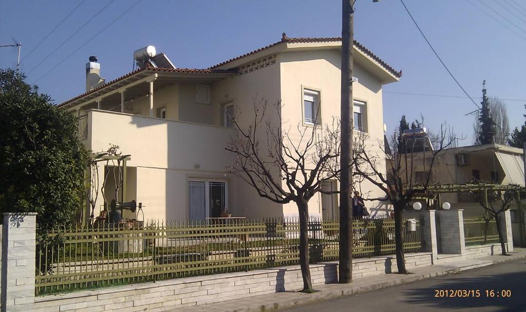 a white house with a fence in front of it at Assos Villa in Káto Ássos