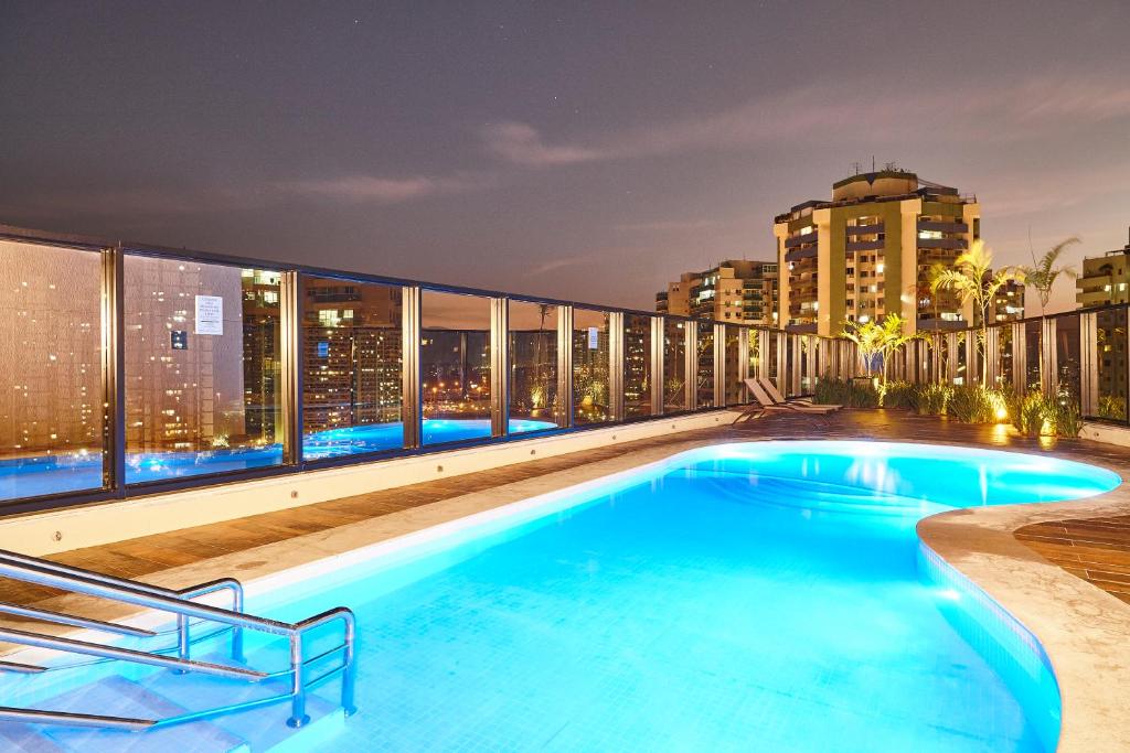 a swimming pool on the roof of a building at night at Radisson Rio de Janeiro Barra in Rio de Janeiro