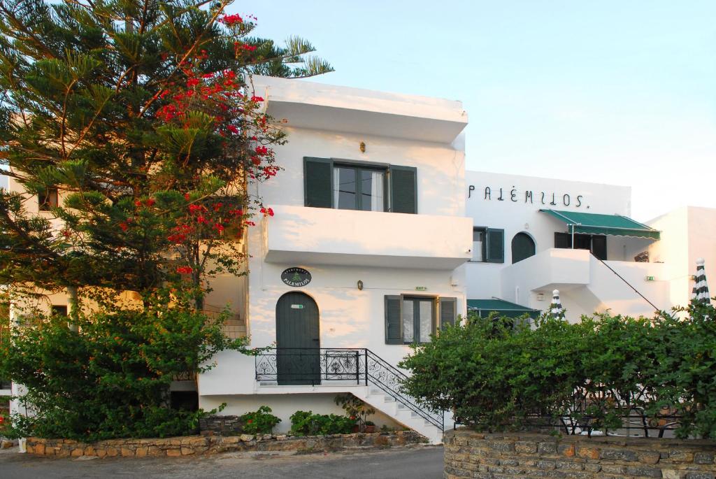 a white building with a tree in front of it at Palemilos Apartments in Elounda