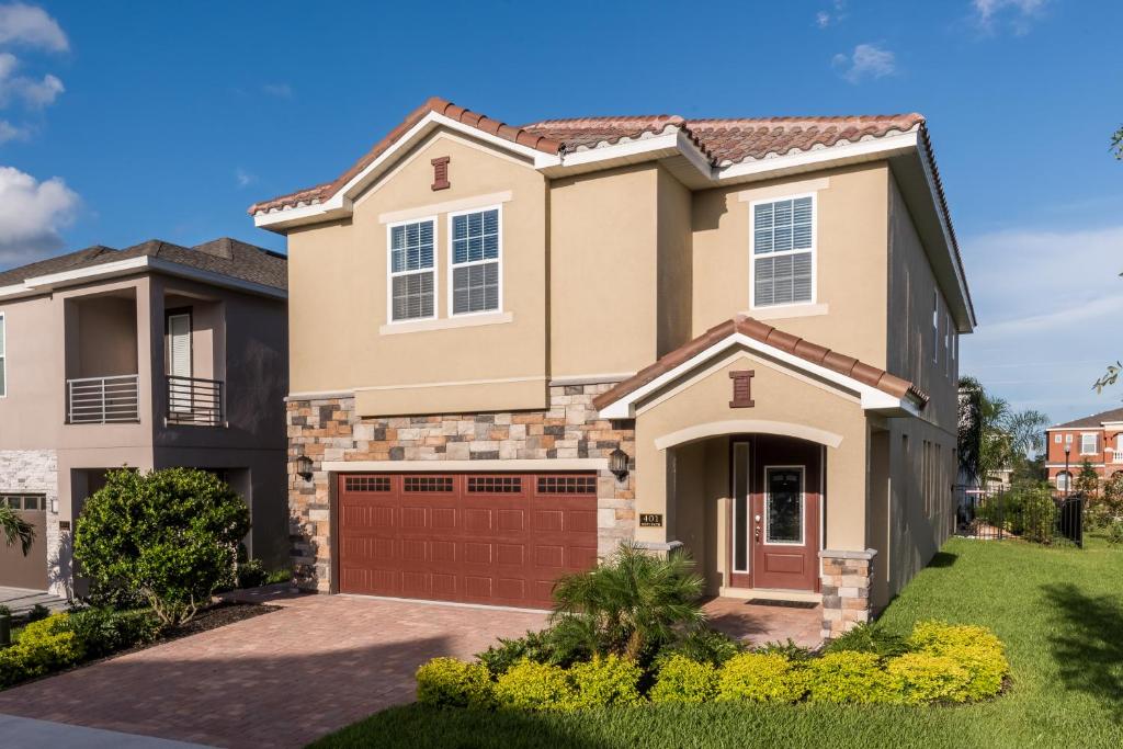 a house with a garage in a residential neighborhood at Vibrant Home by Rentyl Near Disney with Private Pool, Themed Room & Resort Amenities - 401N in Orlando