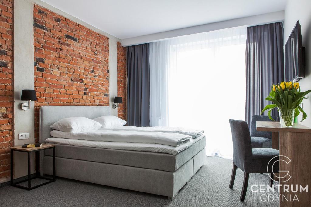 a bedroom with a bed and a brick wall at Gdynia Centrum in Gdynia