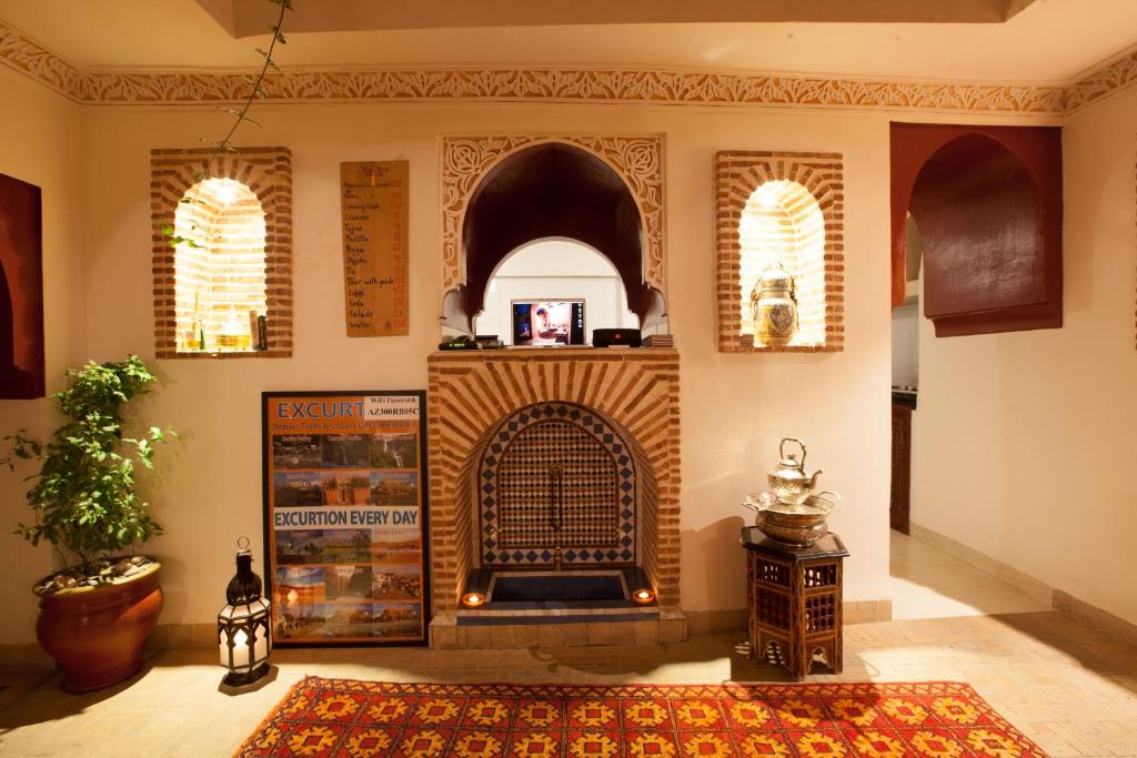 sala de estar con chimenea y alfombra en Riad Hna Ben Saleh, en Marrakech