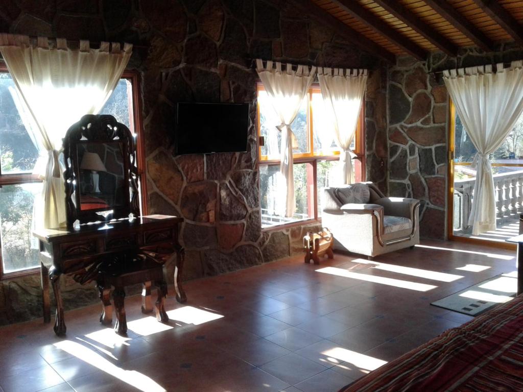 ein Wohnzimmer mit einem Klavier und einer Steinmauer in der Unterkunft Rio Estigia INN in Tlalpujahua
