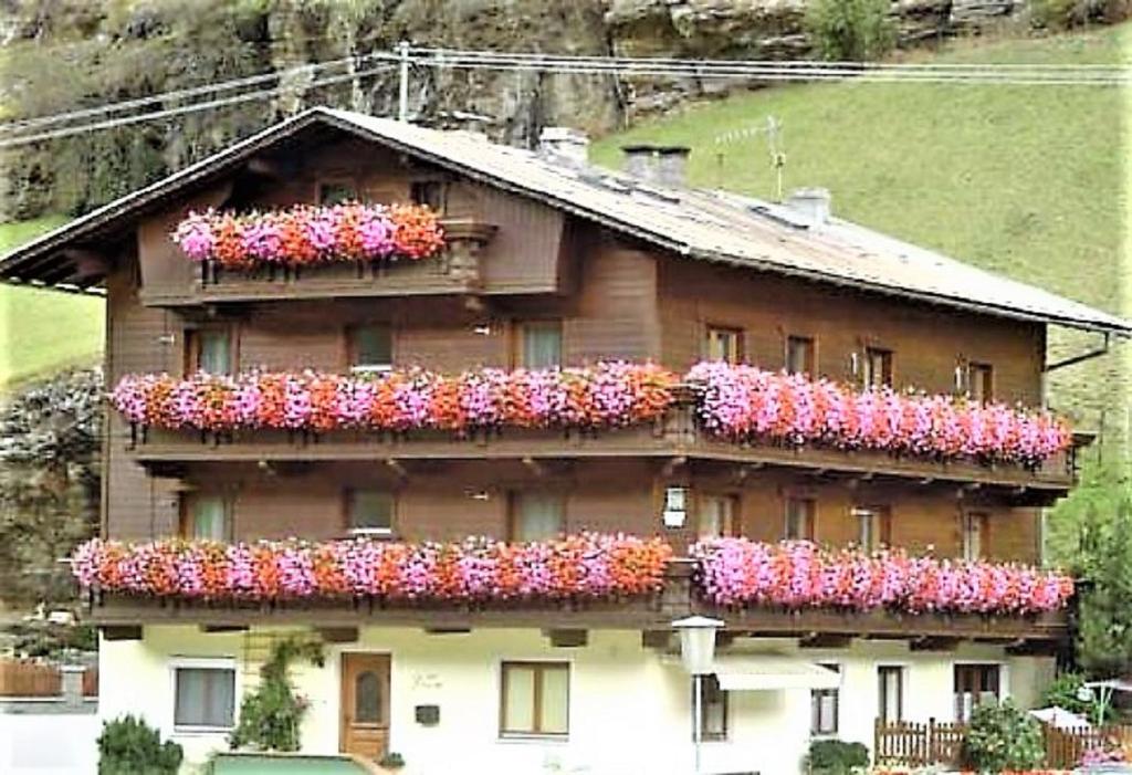 Una casa con muchas flores a un lado. en Haus Ria, en Sölden