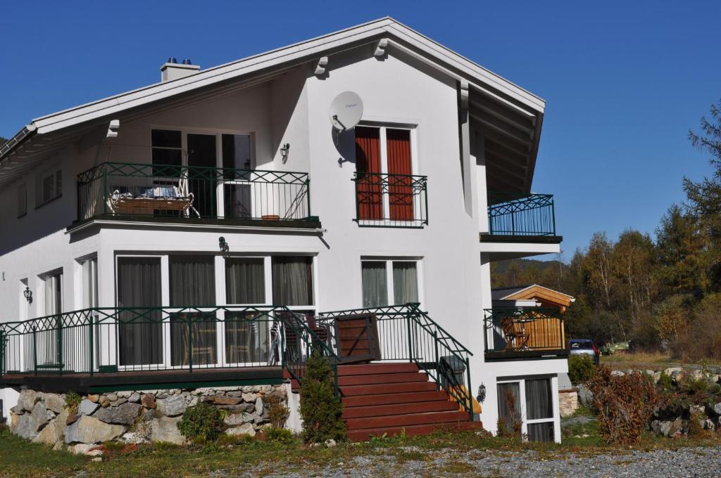 レンゲンフェルトにあるHaus Alpenfloraのバルコニーと階段が備わるホワイトハウスです。