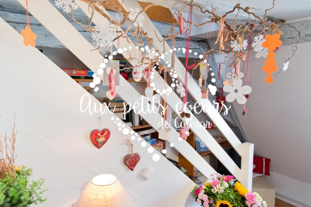 une rampe d'escalier décorée de fleurs et de cœurs dans l'établissement Aux petits cœurs de Colmar PETITE VENISE, à Colmar