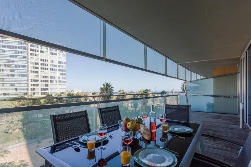 バルセロナにあるUnique Rentals-Seafront Luxe Suitesのバルコニーにテーブルとワイン1杯