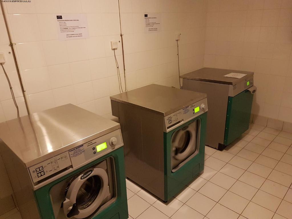 a laundry room with two washing machines in it at Résidence Grand Hôtel in Aulus-les-Bains