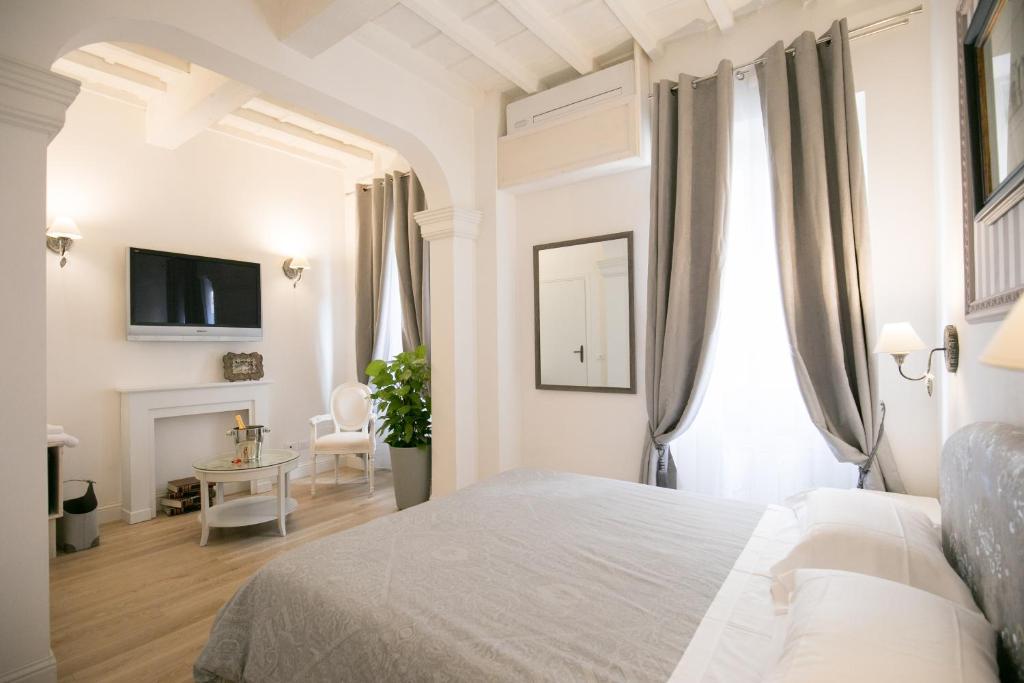 a white bedroom with a bed and a fireplace at Cestello Luxury Rooms in Florence