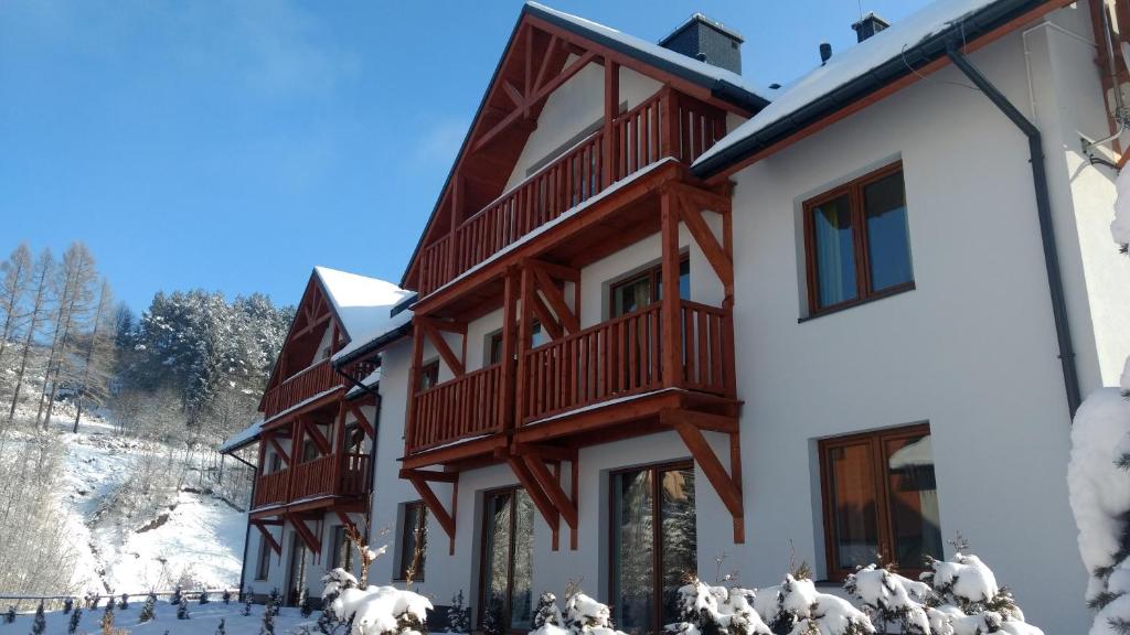 un branco di pecore che corre di fronte a un edificio di Aparthola a Szczawnica