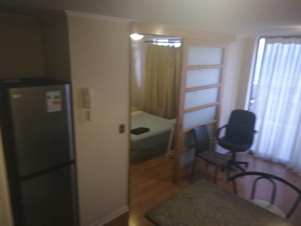 Habitación con nevera, mesa y silla. en Departamento Teniente Uribe, en Antofagasta