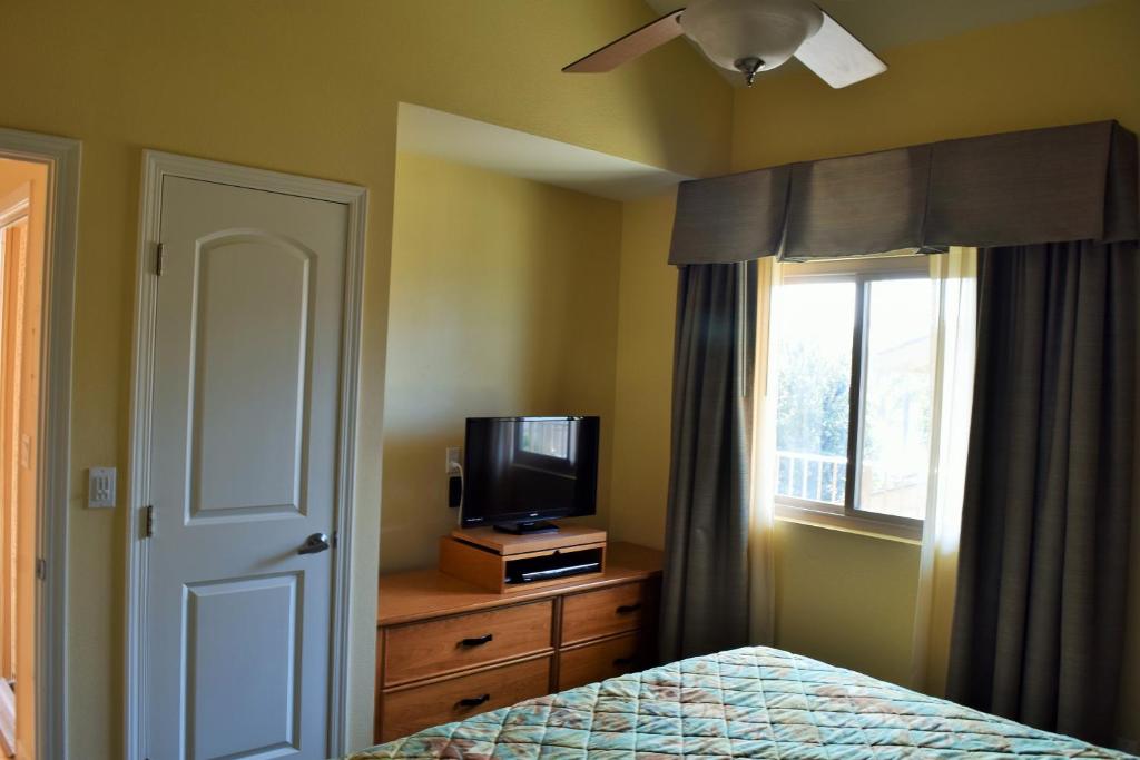 a bedroom with a bed and a tv and a window at Multi Resorts at Aquamarine Villas in Oceanside