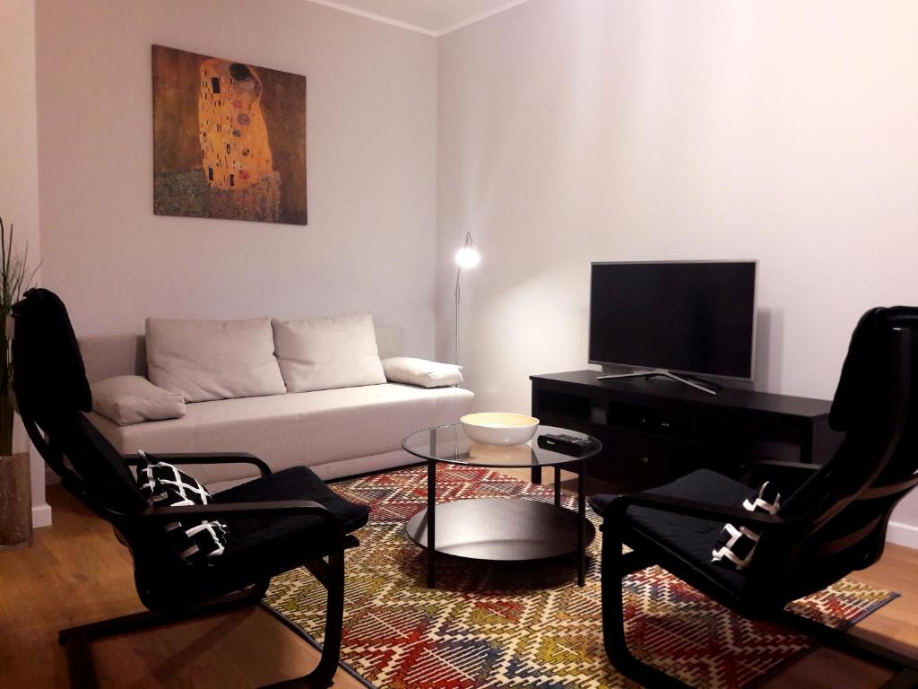 a living room with a couch and chairs and a tv at Modern & quiet in Royal Wilanów with Netflix in Warsaw