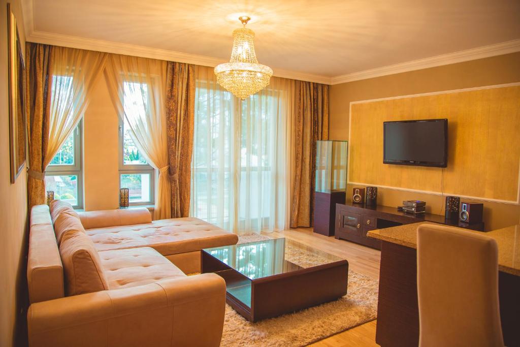 ein Wohnzimmer mit einem Sofa und einem TV in der Unterkunft Apartament Baltic Sand in Świnoujście