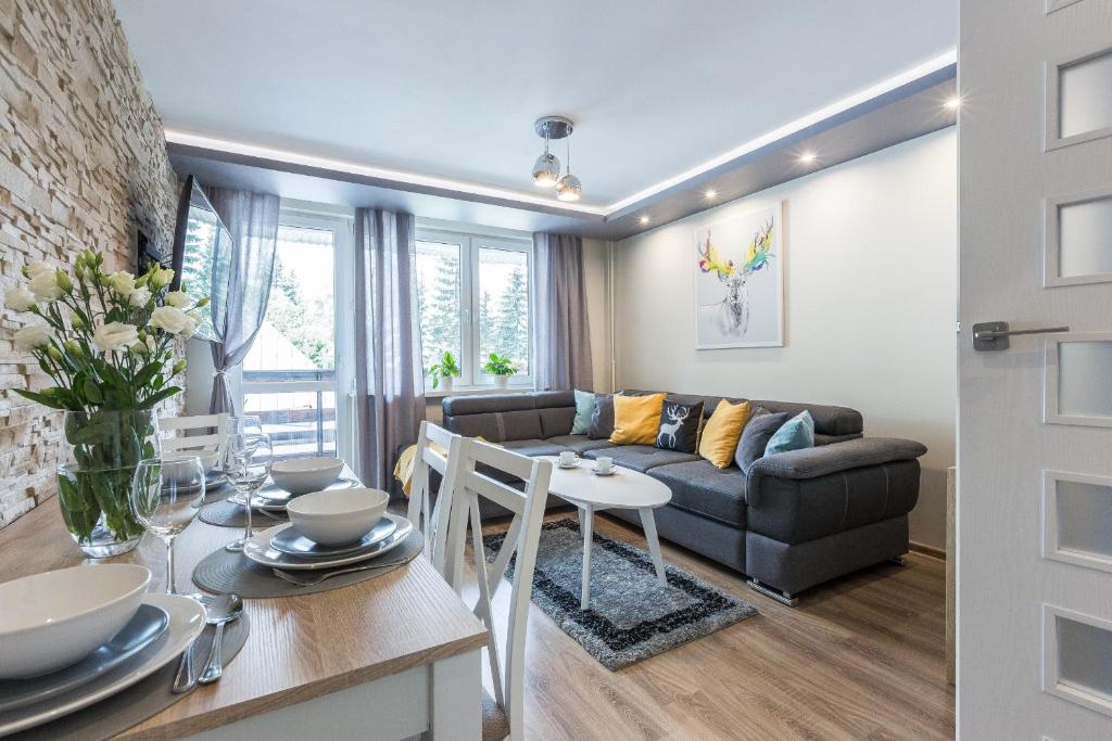 sala de estar con sofá y mesa en Apartamentylove - Apartament Zborowski Centrum, 100m do Krupówek en Zakopane