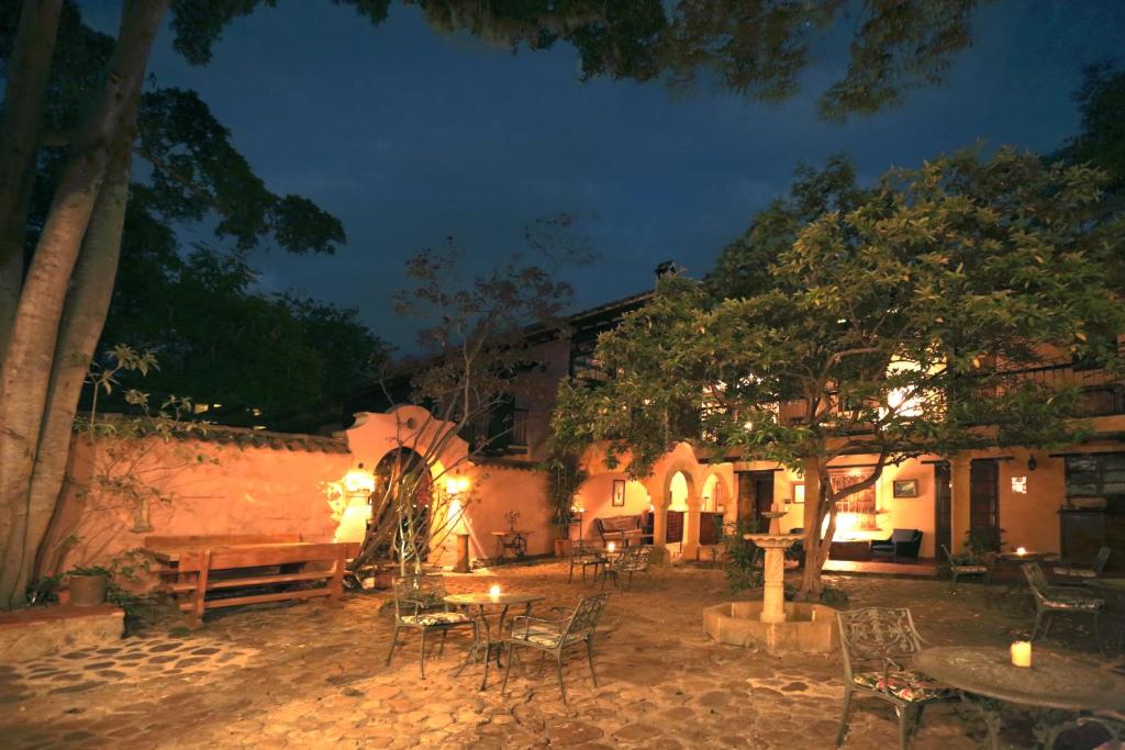 un patio al aire libre con mesas y sillas por la noche en Hotel Plazuela de San Agustín, en Villa de Leyva