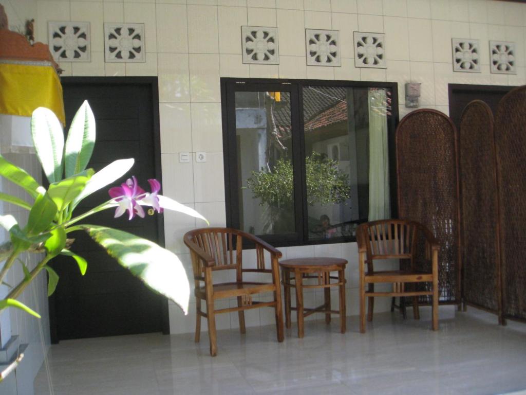 沙努爾的住宿－歐文客房旅館，一套椅子和一张桌子