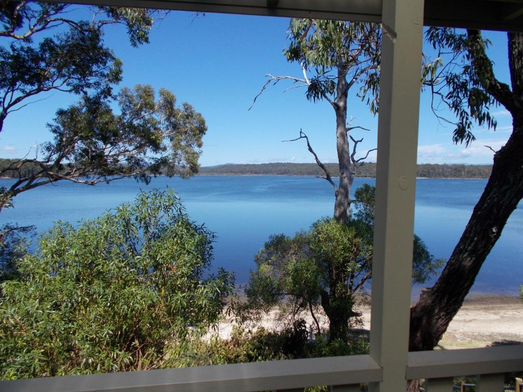 a view of a lake from a house window at Regatta Point Holiday Park in Bermagui