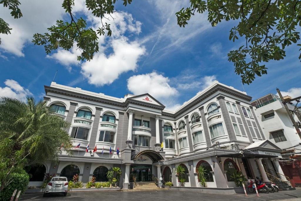 a large white building on a city street at Kiss Gardenhome Chic Hotel in Hat Yai