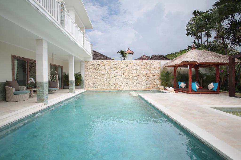 una piscina junto a una casa con cenador en Villa Tarku, en Sanur