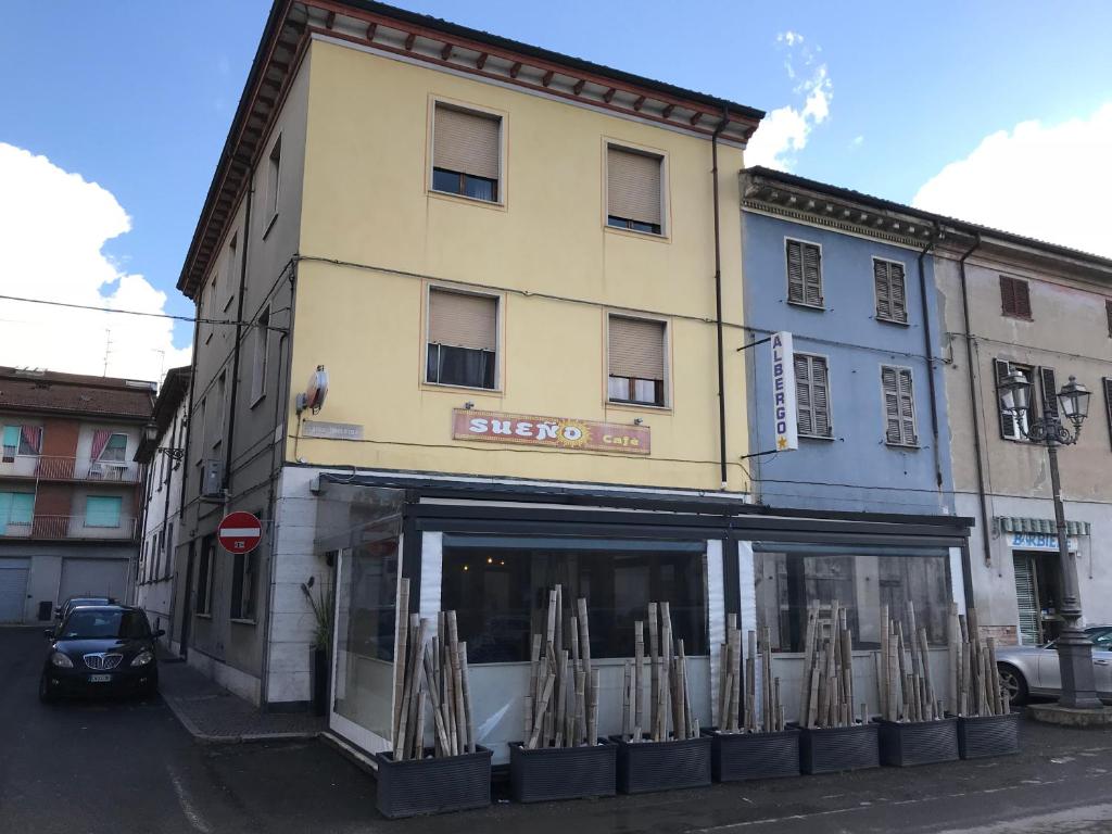 a yellow building with a store on a street at Hotel centrale in Cortemaggiore