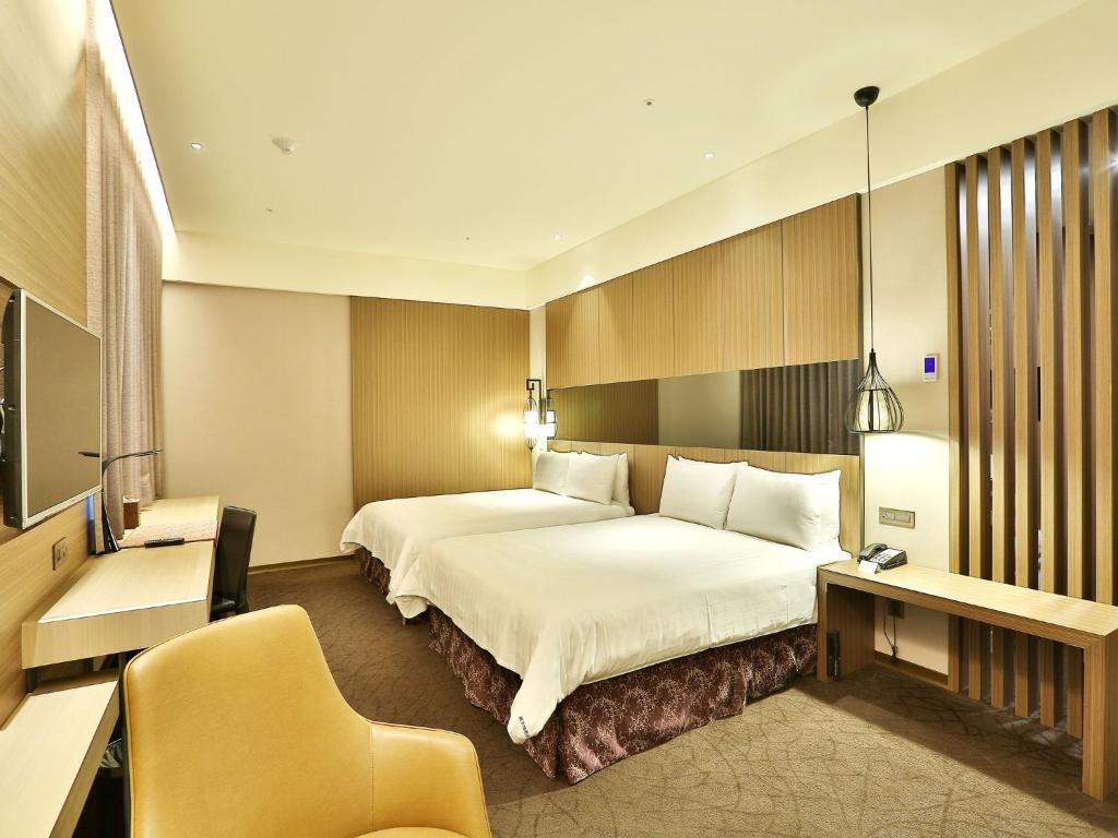 a hotel room with a large bed and a chair at Hotel Intrendy in Taishan