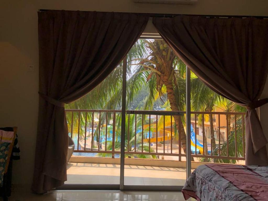 a bedroom with a window with a view of a resort at Gold Coast Morib in Morib