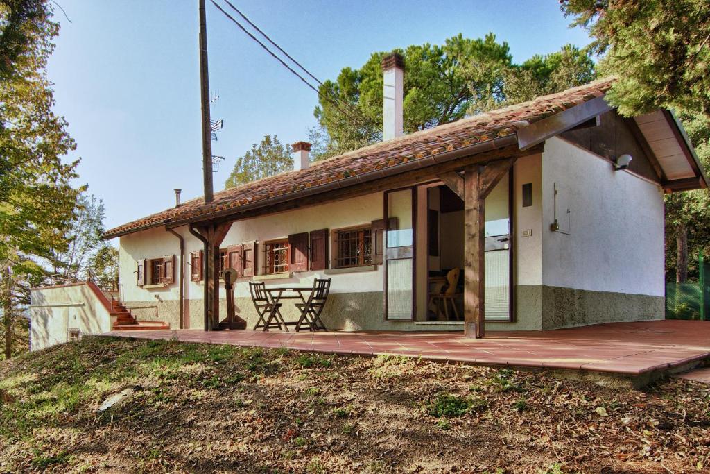 une petite maison avec une terrasse couverte et une terrasse dans l'établissement Podere Riosto Cantina&Agriturismo, à Pianoro