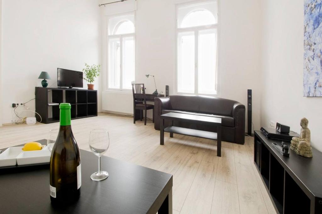 een woonkamer met een fles wijn op een tafel bij Apartment Andrassy in Boedapest