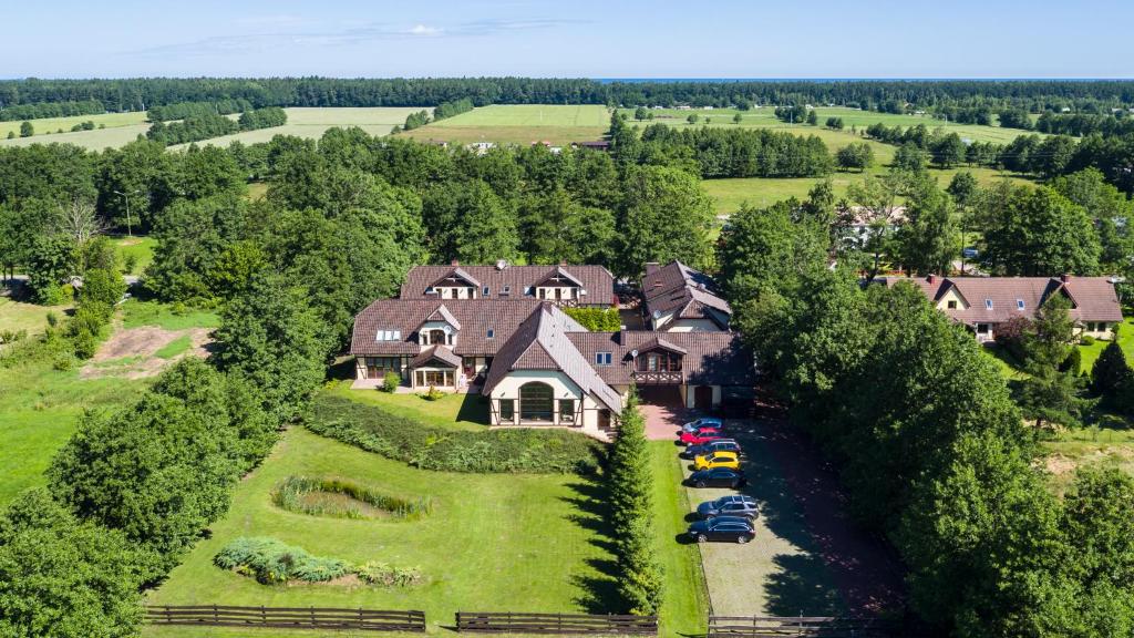 a large house with cars parked in front of it at Pensjonat Margo in Karwieńskie Błoto Drugie