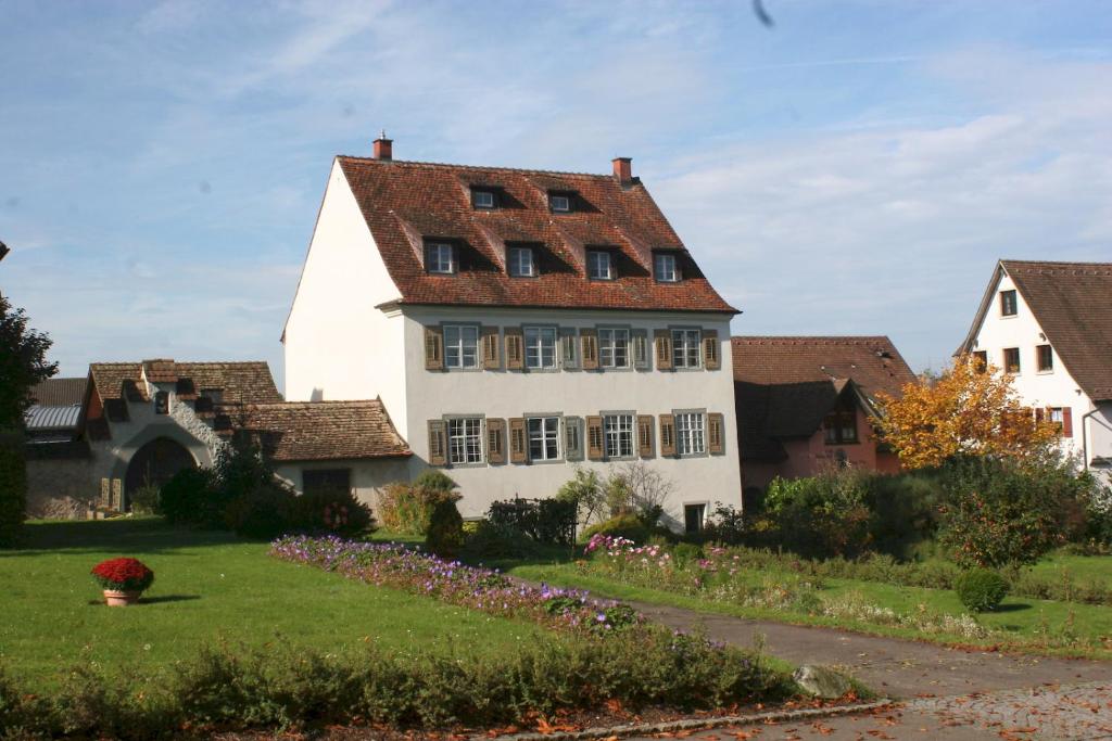 une grande maison blanche avec un toit rouge dans l'établissement Ferienwohnungen Haus Fuchs, à Île de Reichenau