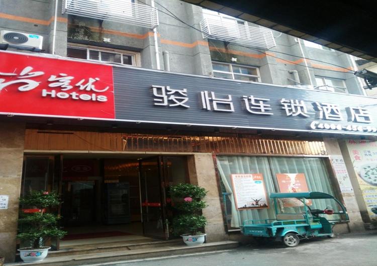 un negozio di fronte a un edificio con scritte sopra di JUNYI Hotel Jiangxi Ganzhou South Gate Square Wenqing Road a Ganzhou
