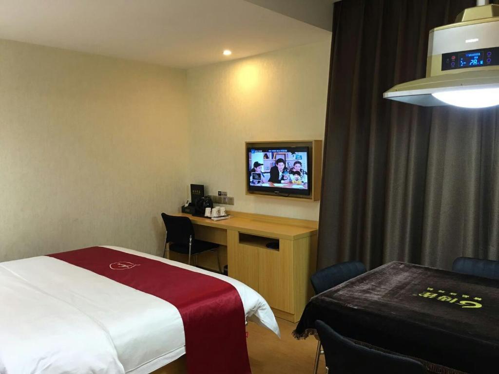 a hotel room with a bed and a desk and a tv at Thank Inn Chain Hotel Hunan Changsha Furong District Railway Station in Changsha