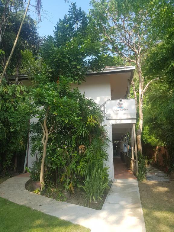a white house with a garage and trees at Palm Garden in Ko Chang