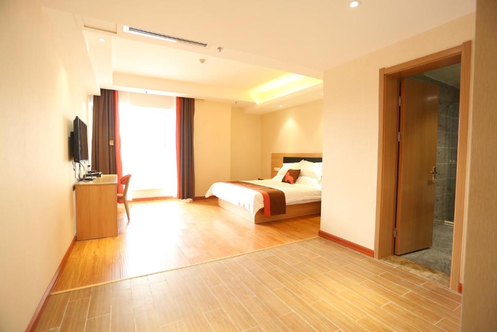 Habitación de hotel con cama y TV en JUNYI Hotel Hebei Shijiazhuang Pingshan Town Wanshou Road, en Pingshan
