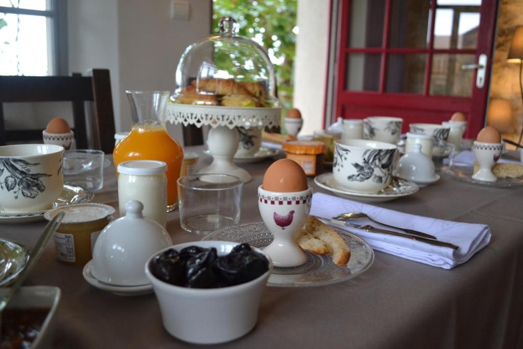una mesa con huevos y tazas en Les Terrasses De Bessou, en Clermont-Dessous