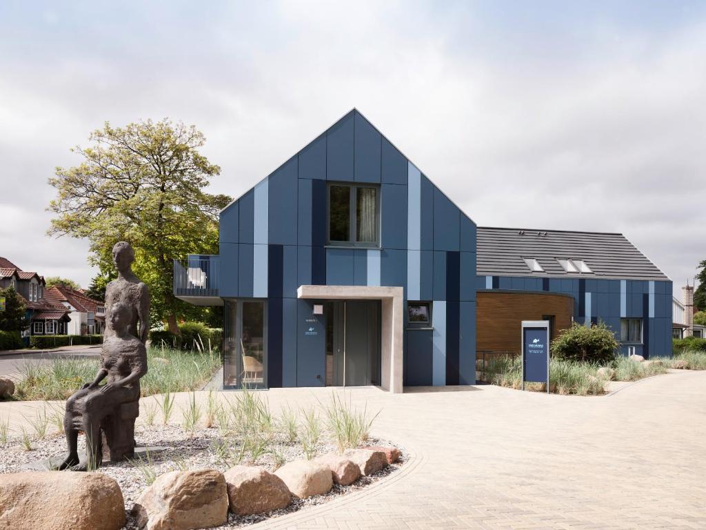 a house with a statue in front of it at Haus am Deich Ferienwohnungen in Prerow