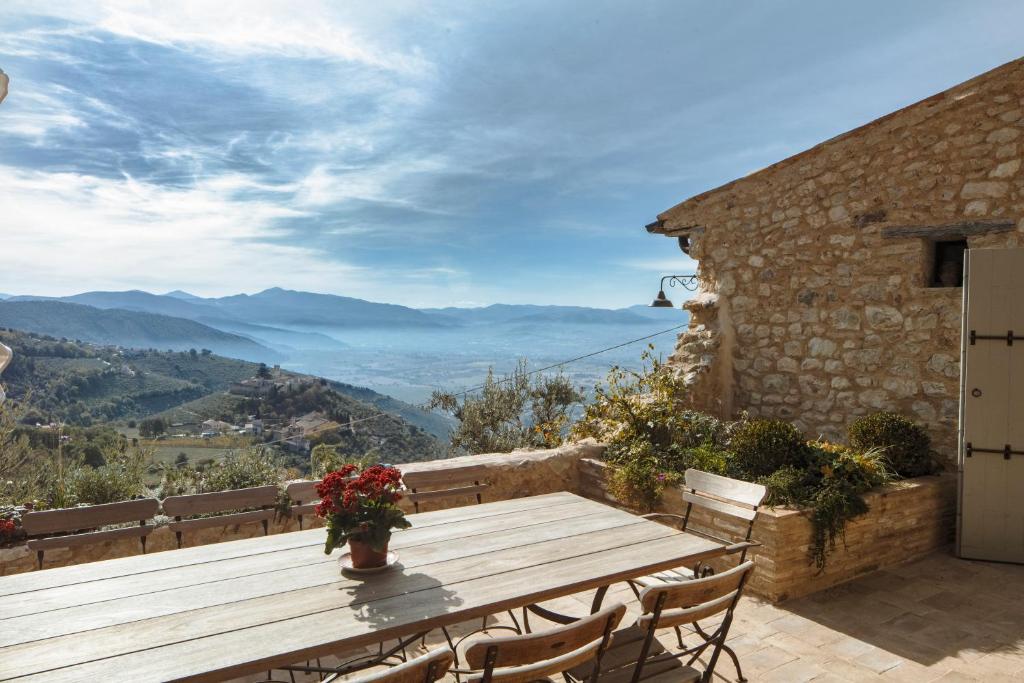 una mesa de madera y sillas en un patio con vistas en Casa di Led, en Campello sul Clitunno