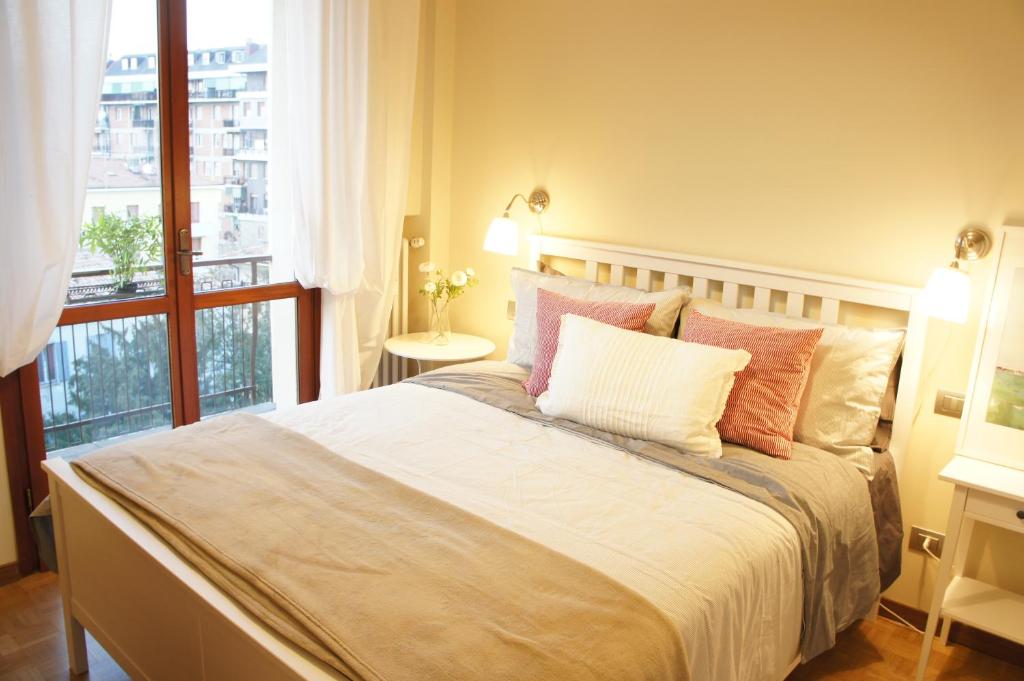 una camera da letto con un grande letto con una grande finestra di Tiraboschi apartment a Modena