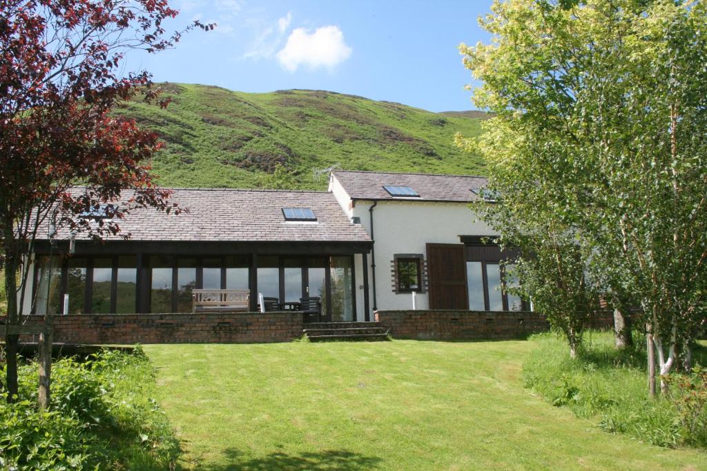 a house with a hill in the background at The Byre in Keswick