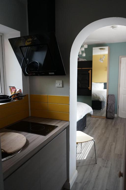 a kitchen with a counter top and a room with a bed at Lincoln Self Catering in Lincoln