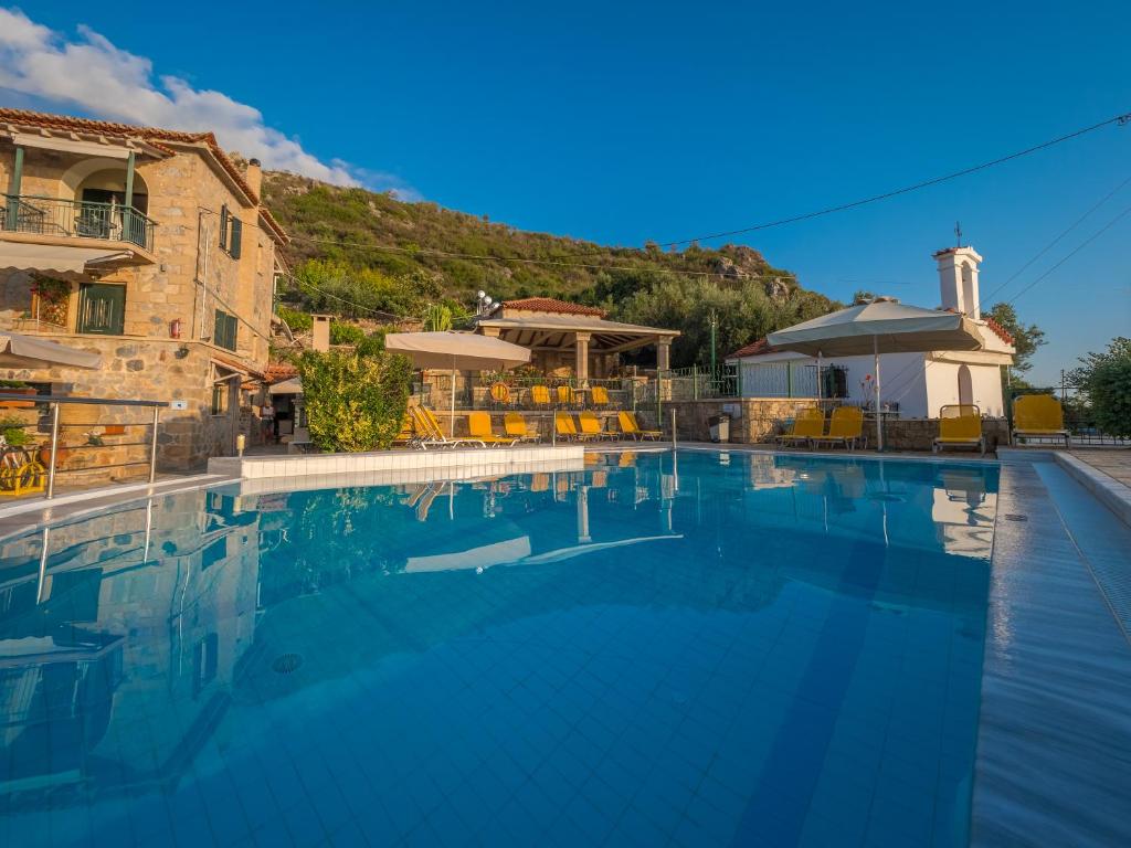 a large swimming pool in front of a building at Palataki in Kardamyli