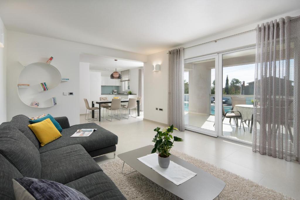 salon z kanapą i stołem w obiekcie Villa L - Villa with 2 separate units w mieście Labin